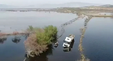 Suyla dolan yolda mahsur kalan TIR şoförü sandalla kurtarıldı